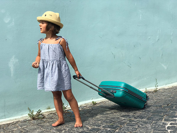 bambina che trascina valigia