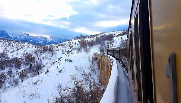 treno storico su ponte nella neve transiberiana