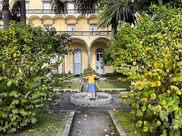 fontana arcani e bambina di spalle con giacca gialla