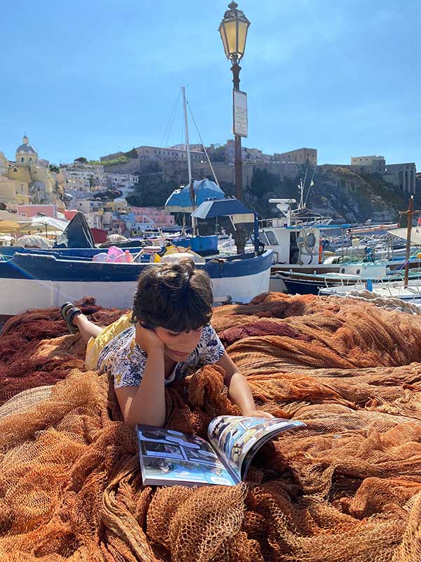 bambino legge libro su reti pescatori